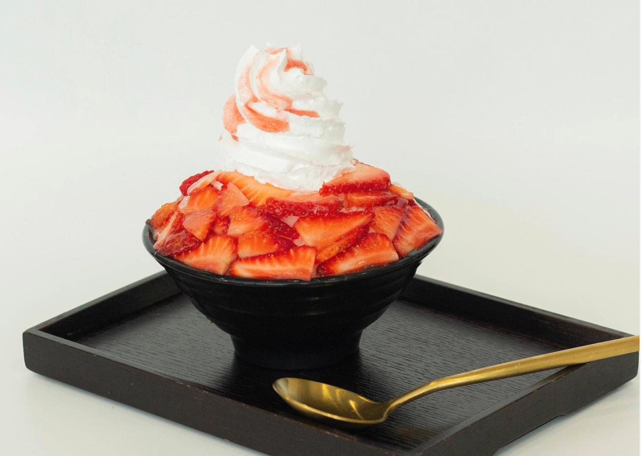 A bowl of shaved ice topped with sliced strawberries