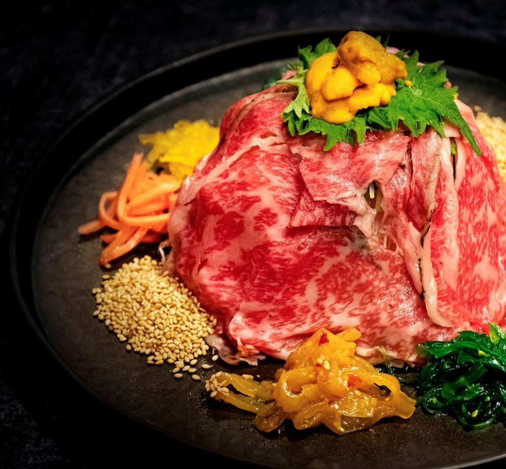 Thinly sliced raw beef topped with uni sesame seeds, seaweed